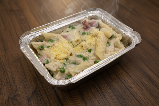 Acontainer filled with baked penne pasta, ham, and fresh peas coated with Parmesan cream sauce.